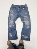 Distressed blue denim jeans with a baggy