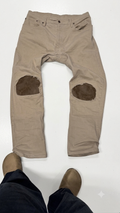 Tan distressed jeans with leather patching on the knee
